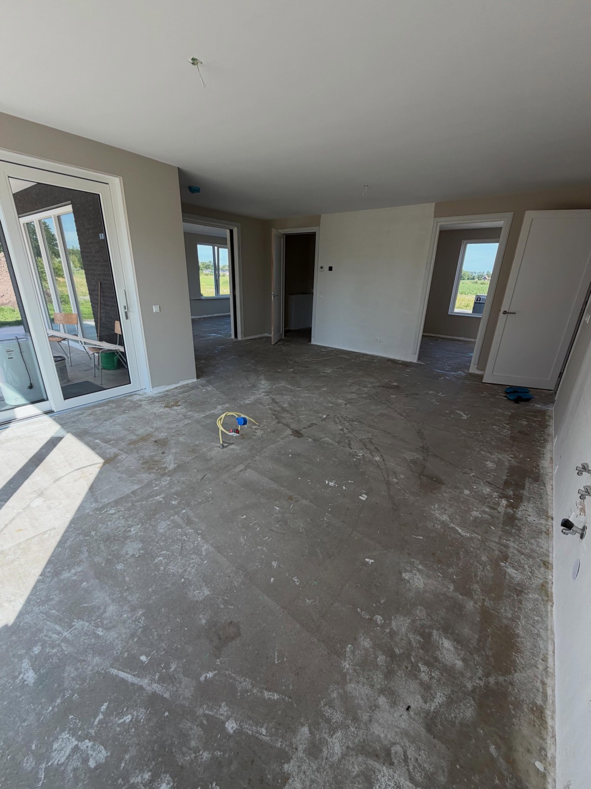 Voor: kale dekvloer in de woonkamer